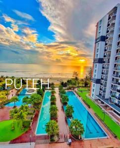 PUTEH Timurbay Beachfront Private Suite Kuantan في كُوانتان: إطلالة على المسبح في فندق مدينة بويرتو الأمراء