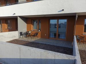 une maison avec une terrasse couverte dotée d'une table et de chaises dans l'établissement A&R Apartament Wenedów I, à Koszalin