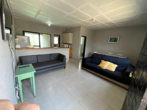 een woonkamer met twee banken en een tafel bij 200m da Praia, Piscina Itanhaém in Itanhaém