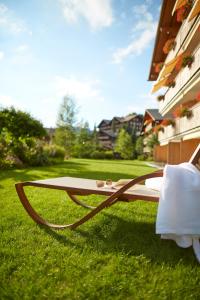 a bench sitting on the grass in a yard at Apartment Gstaaderhof in Gstaad