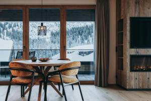 a dining room with a table and chairs in front of a window at Balma Restaurant Apart in Lech am Arlberg