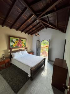 ein Schlafzimmer mit einem Bett und einer offenen Tür in der Unterkunft El Mortiño in San Gil