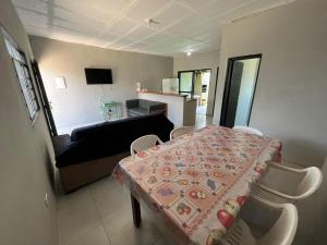 een woonkamer met een tafel en een bank bij 200m da Praia, Piscina Itanhaém in Itanhaém +6 foto's