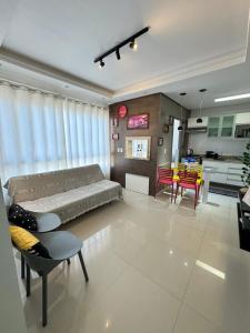 a living room with a bed and a dining room at Apartamento 2 quartos a 2 quadras da praia in Capão da Canoa