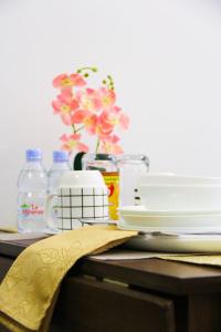 uma mesa coberta com pratos e um vaso com flores em The Loop North Tower em Cagayan de Oro