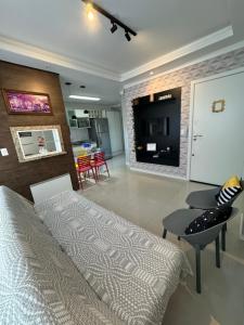 a bedroom with a bed and a table and a kitchen at Apartamento 2 quartos a 2 quadras da praia in Capão da Canoa