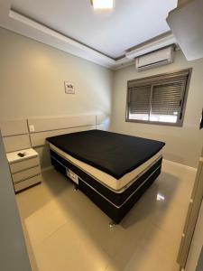 1 dormitorio con 1 cama grande en una habitación en Apartamento 2 quartos a 2 quadras da praia, en Capão da Canoa