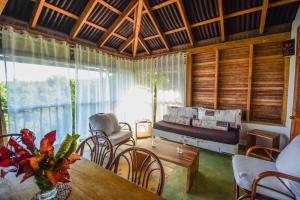Una sala de estar con una mesa y sillas y un sofá. en Clave Verde Ecolodge, en Las Terrenas