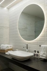 a bathroom with a large white sink and a mirror at Origen 438 Luxury Boutique Hotel in Guadalajara