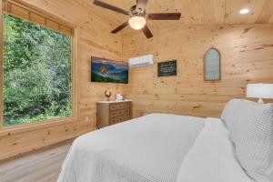 een slaapkamer met een bed en een plafondventilator bij Follies Cottage -Creekside, WIFI, Free Attraction Tickets in Cosby