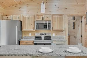 a kitchen with a stove and a refrigerator at Follies Cottage, Pickleball Court, Creek, WIFI, Mountain Views, Starting at 79" in Cosby