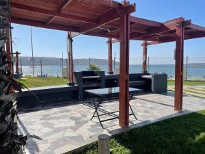 a pavilion with a table and a bench and the ocean at Apartamento junto a la playa - Vistas Increíbles in Coquimbo