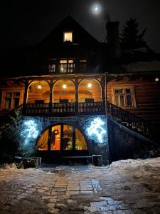 a large building with a balcony on top of it at night at Jak Sobie Pościelisz Tak Się Wyśpisz in Zakopane