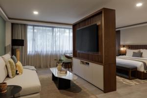 a hotel room with a bed and a flat screen tv at Origen 438 Luxury Boutique Hotel in Guadalajara