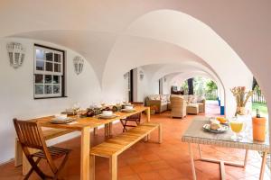 a dining room with a table and chairs and a living room at Casas do Chaparral in Grândola