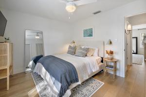 a white bedroom with a bed and a table at The Augustine - Steps to Downtown w King Bed in Mount Dora