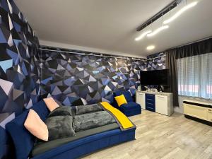 a living room with a bed and a tv at Kitty Downtown Apartman in Debrecen