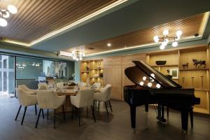 a dining room with a table and a piano at Origen 438 Luxury Boutique Hotel in Guadalajara