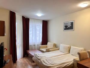 ein Hotelzimmer mit einem Bett und einem Stuhl in der Unterkunft Luxury one bed apartment with hydro bath in Royal Plaza in Borowez