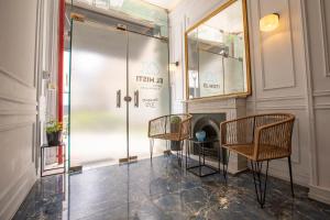 Duas cadeiras e uma cabina de duche em vidro num quarto em El Misti Hotel Buenos Aires Centro em Buenos Aires