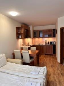 a bedroom with a bed and a table and a kitchen at Luxury one bed apartment with hydro bath in Royal Plaza in Borovets