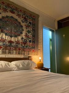 um quarto com uma cama com um grande tapete na parede em Golden Garden Hostel em Ubatuba