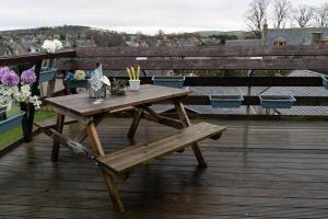 a wooden picnic table on a deck with a bench at Dunedin House -Contractors - Business Travellers in Huntly