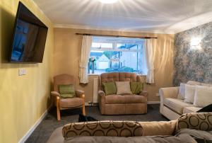 亨特利的住宿－Dunedin House -Contractors - Business Travellers，带沙发和椅子的客厅以及窗户。
