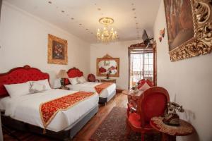 um quarto com 2 camas, uma cadeira e um lustre em Casona Corrales Hotel Boutique em Cusco