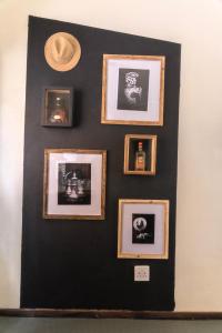a black wall with framed pictures on it at Industrial farm stay in Polokwane in Eerstegoud