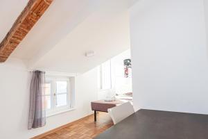 ein weißes Zimmer mit einem Tisch und einem Fenster in der Unterkunft Le Finestre Boutique Apartments in Triest