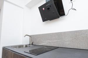 a kitchen counter with a sink and a microwave at Hurban Apartments Venezian in Trieste