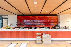 a restaurant with a large counter with a red wall at MO Hotel Bangkok in Pom Prap