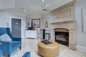 a living room with a fireplace and a blue chair at Apartment with Panoramic City view of Ballston in Arlington