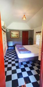 um quarto com uma cama e um piso em xadrez em ปายสามหมอก em Pai