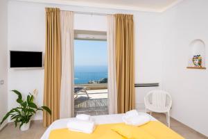 una camera con un letto giallo e una grande finestra di L'Acquolella a Positano