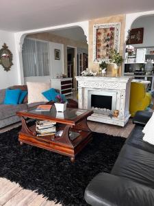 a living room with a coffee table and a fireplace at Parcelacion Bosque de Hadas in Popayan