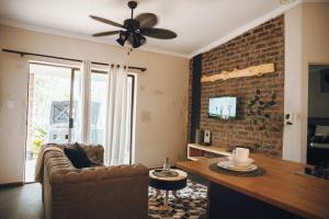 a living room with a couch and a brick wall at Industrial farm stay in Polokwane in Eerstegoud