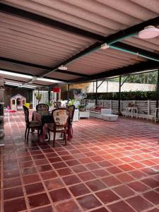 a patio with a table and chairs under a roof at Parcelacion Bosque de Hadas in Popayan