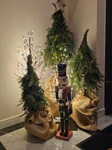 a nutcracker in front of two christmas trees at Altara Apartamenty Centrum - Free Parking in Zakopane