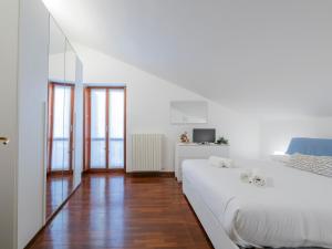 a white bedroom with a large white bed and wooden floors at B&B La Ringhiera - Meda 43 in Milan