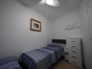 ロザスにあるInmoSantos Oasis A1のベッドルーム1室(ベッド2台、ドレッサー、テレビ付)