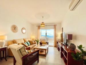 ein Wohnzimmer mit einem Sofa und einem TV in der Unterkunft Marina Sunrise, Preciosas Vistas al Mar in La Herradura