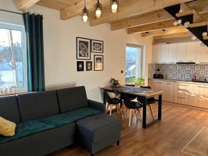 a living room with a couch and a table at Cichata - domek w Bieszczadach in Czarna