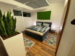 een slaapkamer met een bed en een potplant bij „1. SALZBURG work & sleep luxury apartment“ für arbeiten & wohnen ! in Salzburg