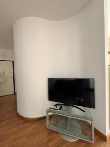een woonkamer met een flatscreen-tv aan een witte muur bij DEA apartment in Albenga