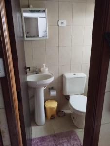uma pequena casa de banho com WC e lavatório em Chalé simples em camping com bastante movimento em Atibaia