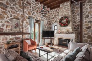 a living room with a couch and a fireplace at Parnassus Woodstone Chalet in Áno Polídhrosos