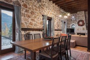 eine Küche und ein Esszimmer mit einem Holztisch und Stühlen in der Unterkunft Parnassus Woodstone Chalet in Áno Polídhrosos