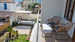 two chairs and a table on the balcony of a house at Dommu Livia in Lotzorai